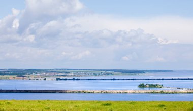 Yaz manzarası, mavi gökyüzünde güzel bulutlar güneşli bir günde geniş bir nehrin üzerinde.
