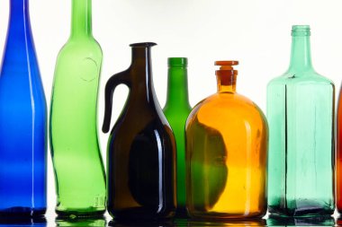 Beyaz arka plan stüdyosuna izole edilmiş kapaksız güzel renkli boş şişelerin yakın plan görüntüleri.