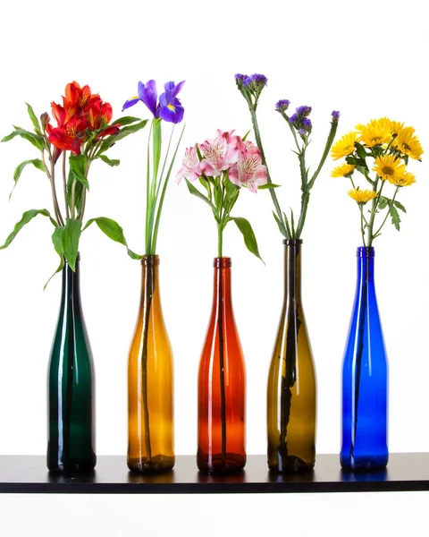 Close Beautiful Flowers Colorful Bottles White Background Studio — Stock Photo, Image