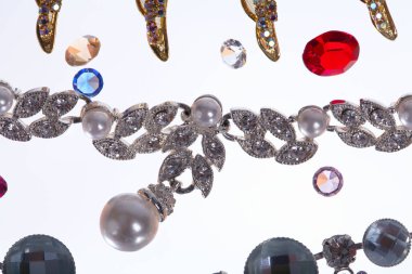 Makro zarif çeşitli mücevherler, kolyeler ve küpeler. Beyaz arka plan stüdyosunda renkli taşlar.