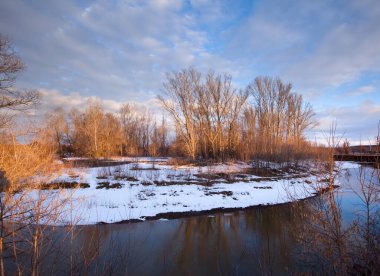 İlkbaharın başlarında gün batımında nehirde eriyen buz ve kardan oluşan bahar manzarası