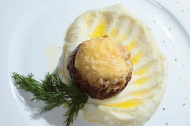 Makro ikinci tabak patates püresi. Beyaz tabakta dereotuyla süslenmiş pirzola.