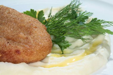 Beyaz tabakta patates püresi ve makro pirzola.