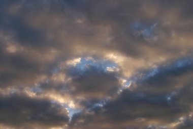 Güneş batarken, mavi gökyüzünün arka planında, izole güzel, parlak bulutların yakın plan görüntüsü.