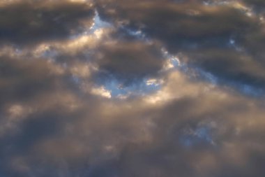 Güneş batarken, mavi gökyüzünün arka planında, izole güzel, parlak bulutların yakın plan görüntüsü.