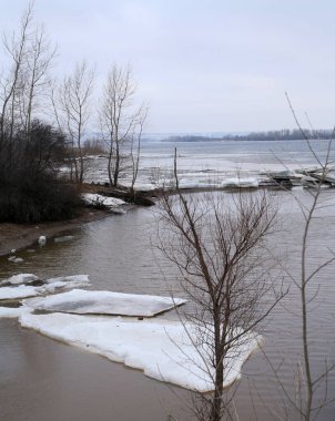 Baharın başlarında bulutlu bir günde nehir üzerindeki buz tabakası sürükleniyor.