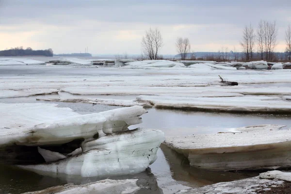 Baharın başlarında bulutlu bir günde nehir üzerindeki buz tabakası sürükleniyor.