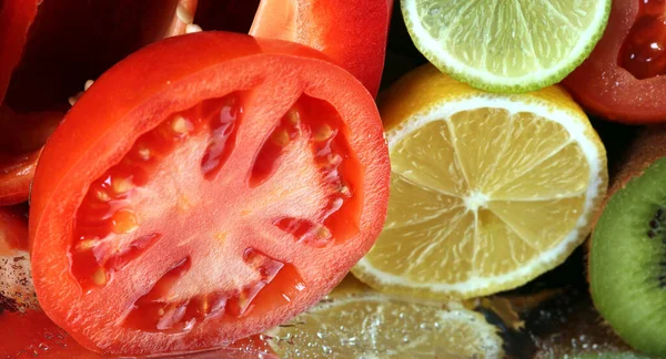 close-up of assorted cut ripe fruits and vegetables studio