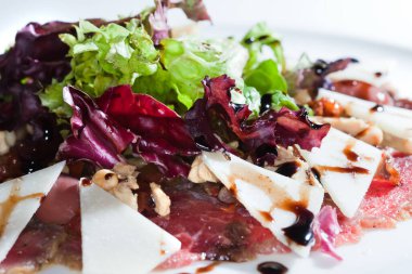 Yakın plan güzel iştah açıcı salata. Beyaz tabakta, karanlık stüdyo arka planında. 