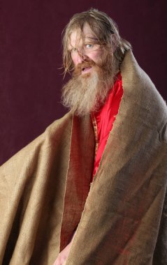 Uzun sakallı, bıyıklı ve kırmızı gömlek stüdyosunda ıslak sarı saçlı kutsanmış kişinin portresi.