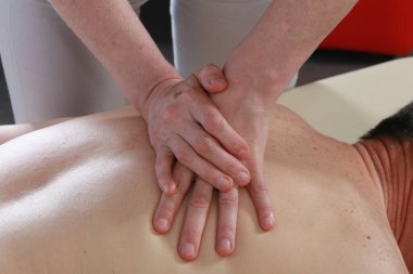 Masörün elleri izole edilmiş. Bir seans sırasında erkeğin sırtındaki kadın. Stüdyo.