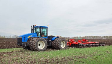 Güçlü bir traktörde tarla sürme işi