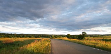 Gün batımında manzara dramatik bulutlar yolun arka planında