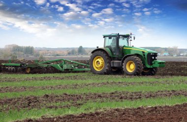 Güçlü bir traktörde tarla sürme işi