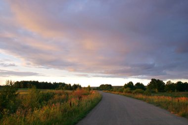Gün batımında manzara dramatik bulutlar yolun arka planında