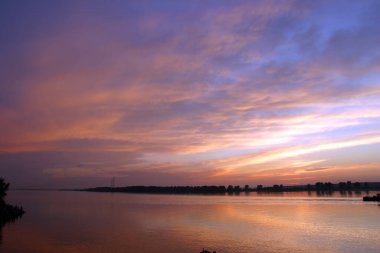 Nehirdeki en parlak gün batımı. Parlayan bulutlar