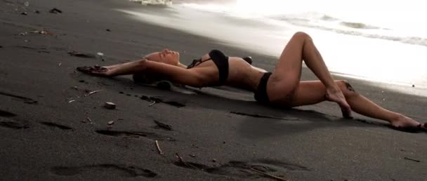 Młoda Opalona Dziewczyna Leżała Głębokiej Czarnej Plaży Piaskiem Wrażliwym Pozowaniem — Wideo stockowe