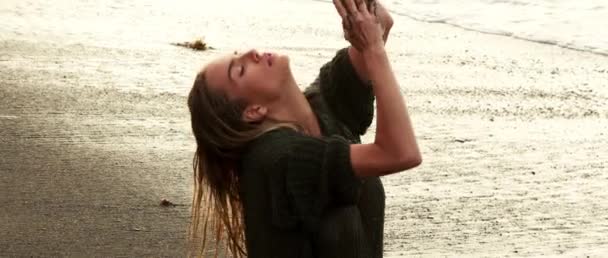 일출을 모래사장에서 여자가 수영복 블라우스 각도에서 섹시하고 감성적으로 포즈를 취한다 — 비디오