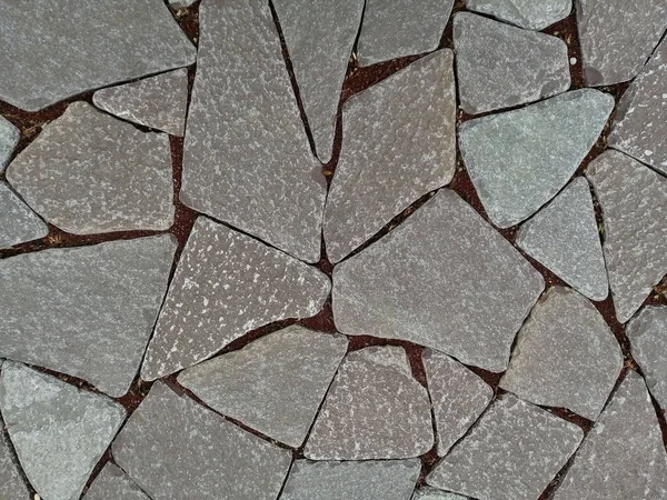 Platte stenen en rode granieten chips tussen als achtergrond — Stockfoto
