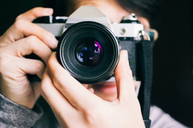 Close up man taking photos with an old vintage film camera