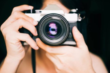 Close up man taking photos with an old vintage film camera
