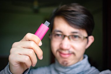 Concept of bad guy with top secret information in the thumb drive, Man holding USB momory stick