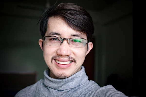 Close up Asian man face with eyeglasses smiling
