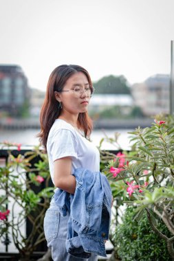 Beyaz tişörtlü, yırtık kotlu Asyalı inek kadın.