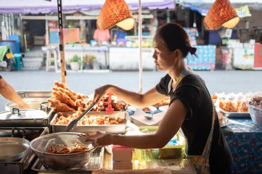 Bangkok, Tayland, 27 Ekim 2019 Asyalı kadın sokak satıcısı kendi dükkanında kızarmış tavuk satıyor.