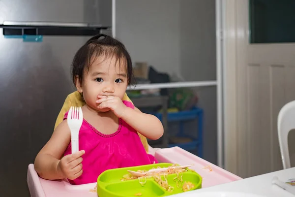 小女孩拿着叉子吃面条 — 图库照片