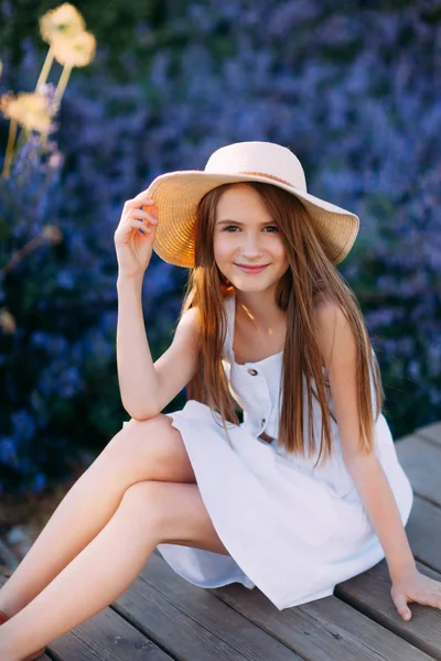 Lavanta parkında oturan beyaz elbiseli küçük kızın portresi