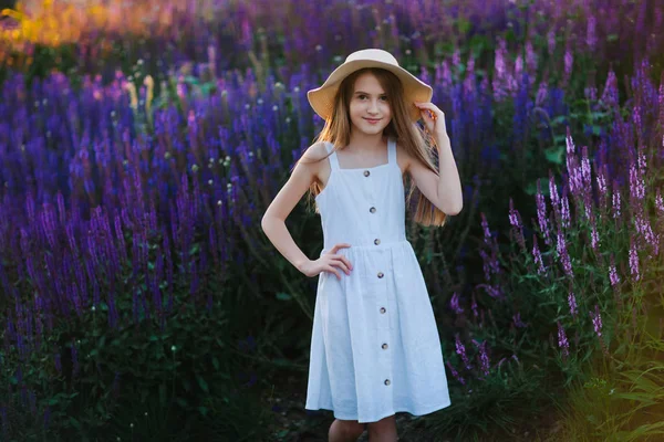 Улыбающаяся Маленькая Девочка Белом Платье Парке Полном Фиолетовых Цветов — стоковое фото