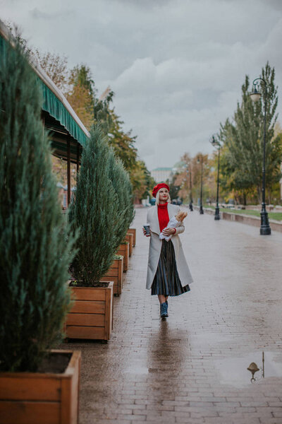 Nice young girl in white coat and red beret joy and happy. 