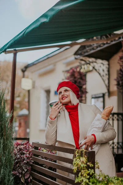 Beyaz ceketli, kırmızı bereli, neşeli ve mutlu genç bir kız..