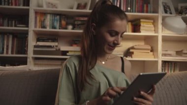 Kadın internette geziniyor ya da akşam saatlerinde tablet üzerinden alışveriş yapıyor.