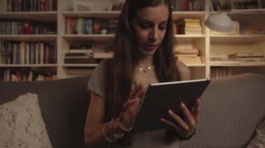 Kadın internette geziniyor ya da akşam saatlerinde tablet üzerinden alışveriş yapıyor.