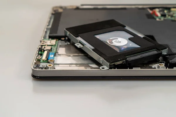 Жесткий диск подключен и лежит на разобранном ноутбуке, вид под углом — стоковое фото