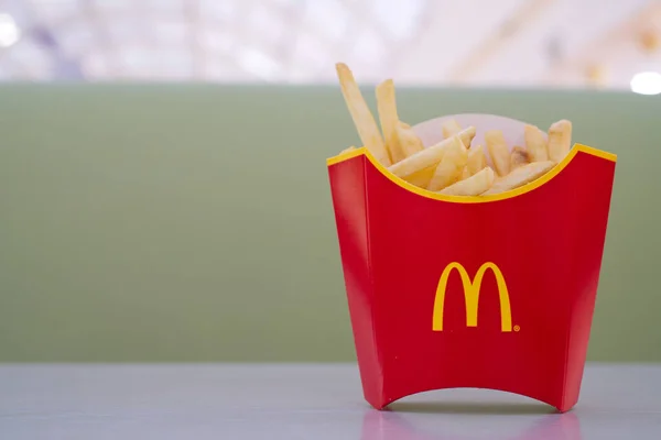 MacDonalds patatine fritte sul tavolo, sfondo sfocato — Foto Stock