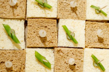 Bir sürü beyaz ve siyah ekmek ve biraz yeşillik, üstten bakınca satranç gibi görünüyor. 