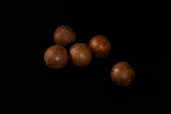 Cinq Noix Macadamia Isolées Sur Fond Noir — Photo