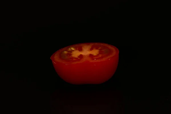 Färsk halv skivad tomat på svart bakgrund. — Stockfoto