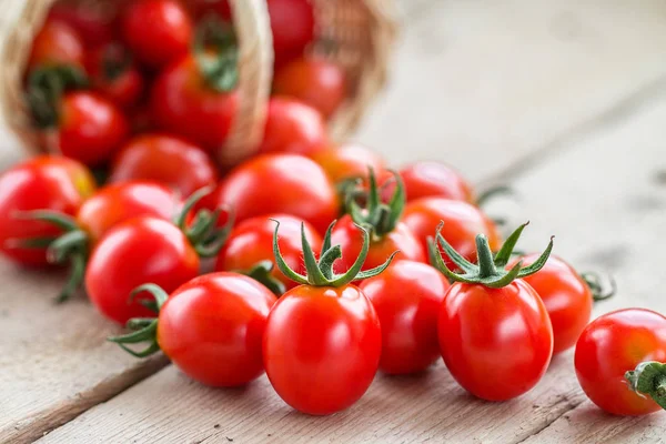 Small Red Cherry Tomatoes Spill Out Wicker Basket Old Wooden — Stock Photo, Image