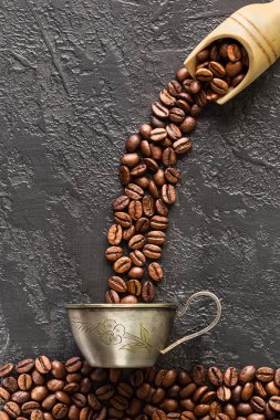 Kahve fincanı kavrulmuş fasulye taş zemin üzerine. Üstten görünüm metniniz için kopya alanı ile. Gıda ile koyu arka plan 
