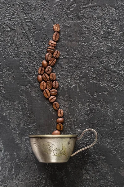 kahve çekirdekleri ve kupa gri beton zemin üzerine. Kahve fincanı kavrulmuş fasulye ile. Yukarıdan kahve görünümü yapma kavramı