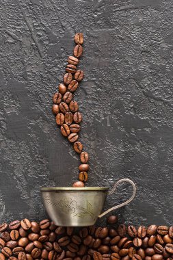 kahve çekirdekleri ve kupa gri beton zemin üzerine. Kahve fincanı kavrulmuş fasulye ile. Yukarıdan kahve görünümü yapma kavramı