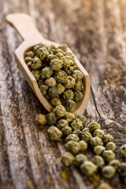 Yeşil peppercorns ahşap masa bir kaşık içinde. Baharat ve otlar tahta kaşıklar içinde yemek pişirmek için. Organik gıda, sağlıklı yaşam, alan metin, afiş