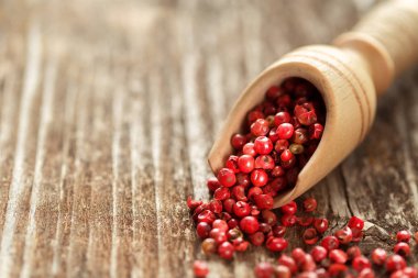 Ahşap masa bir kaşık kırmızı karabiber.