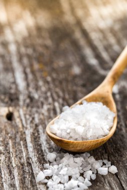 Ahşap masa bir kaşık içinde deniz tuzu. Baharat tahta kaşıklar içinde yemek pişirmek için. Organik gıda, sağlıklı yaşam, alan metin, afiş