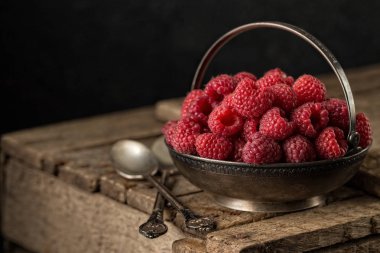 Ahududu rustik tablo ile kırsal natürmort. eski ahşap arka plan üzerinde taze sulu çilek