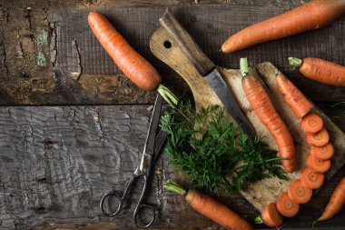 Rustik koyu arka plan üzerinde taze havuç ile düz yatıyordu kompozisyon. Sebze vitaminler Keratin. Doğal organik sağlıklı gıda kavramı. Üstten görünüm